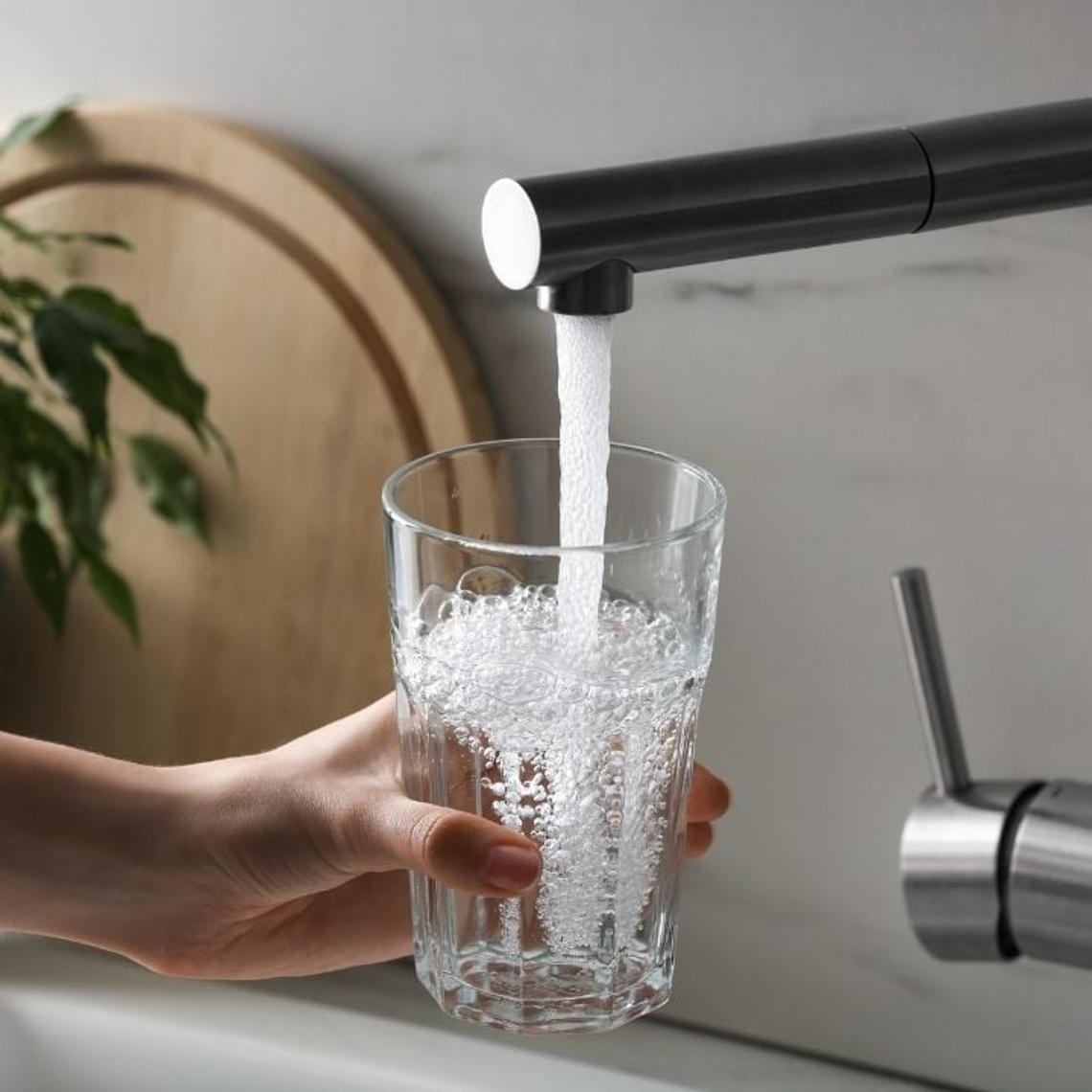 woman filling a glass from a kitchen tap with fitted aerator