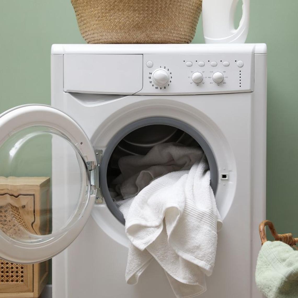 A washing machine with the door open and a towel inside