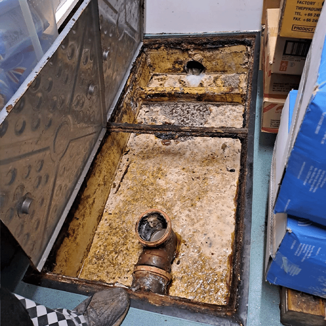 Picture of a full dirty grease trap 