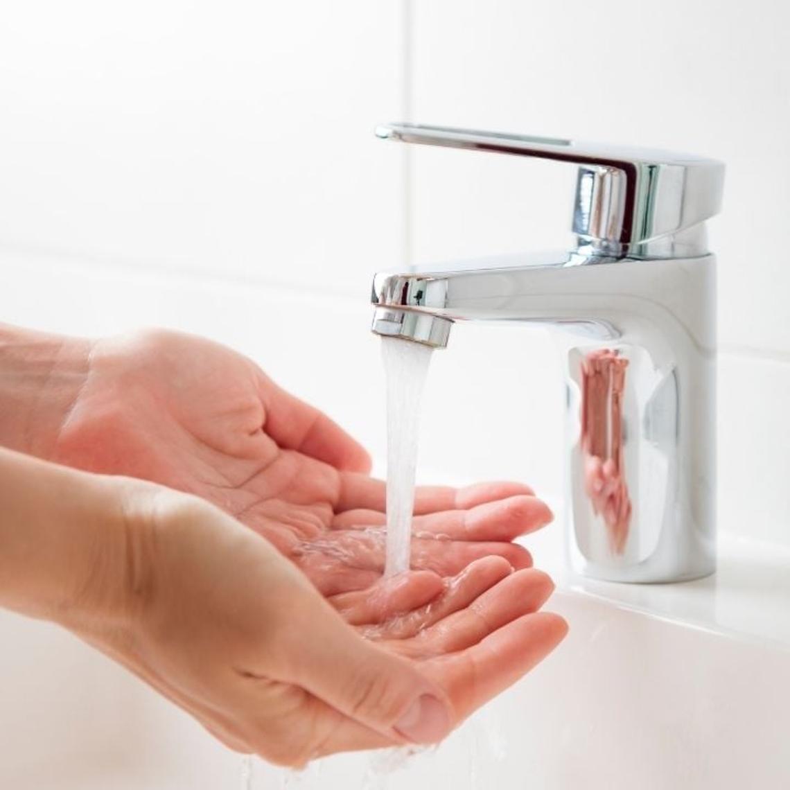 water pouring onto hands from an aerator tap