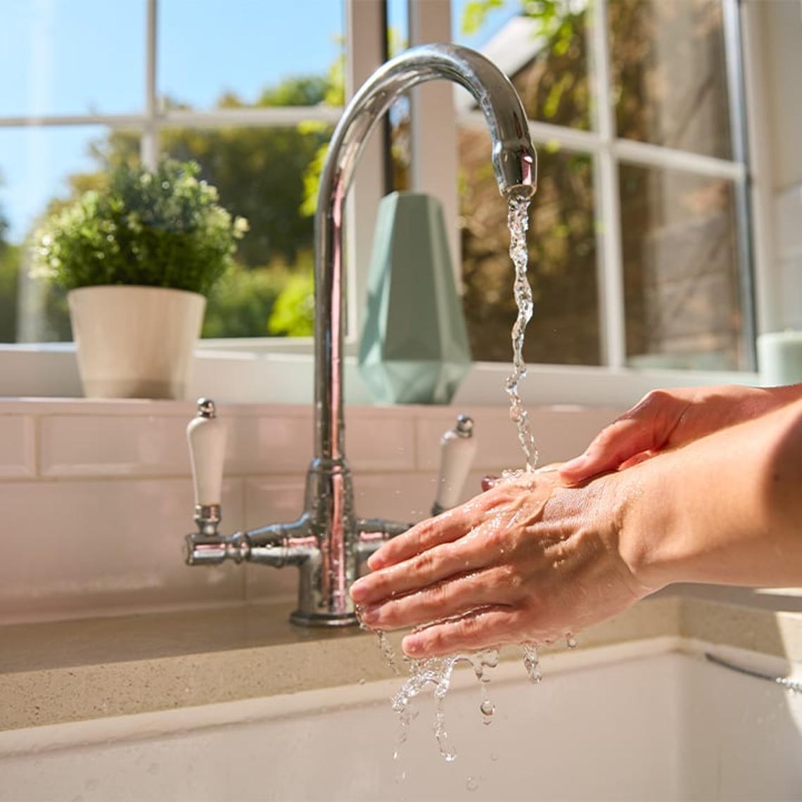 Running a tap in kitchen and washing hands