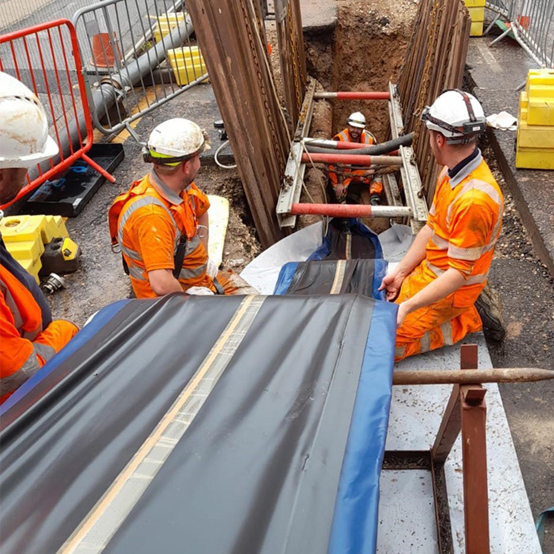 Workers preparing to line a sewer pipe