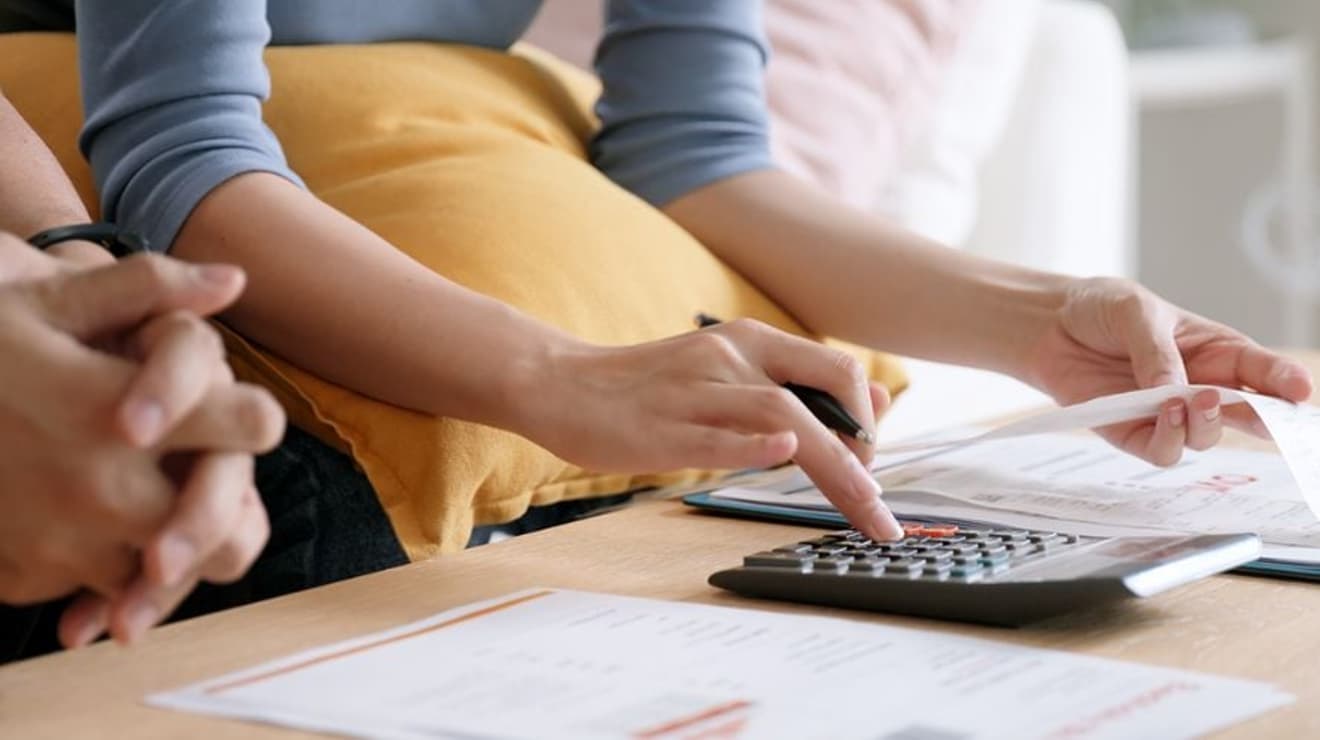 Lady using a calculator holding paperwork