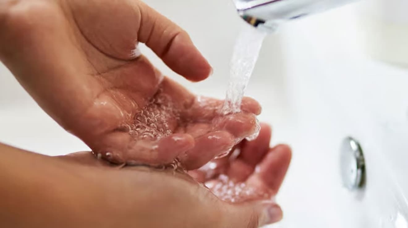 Washing hands under a tap