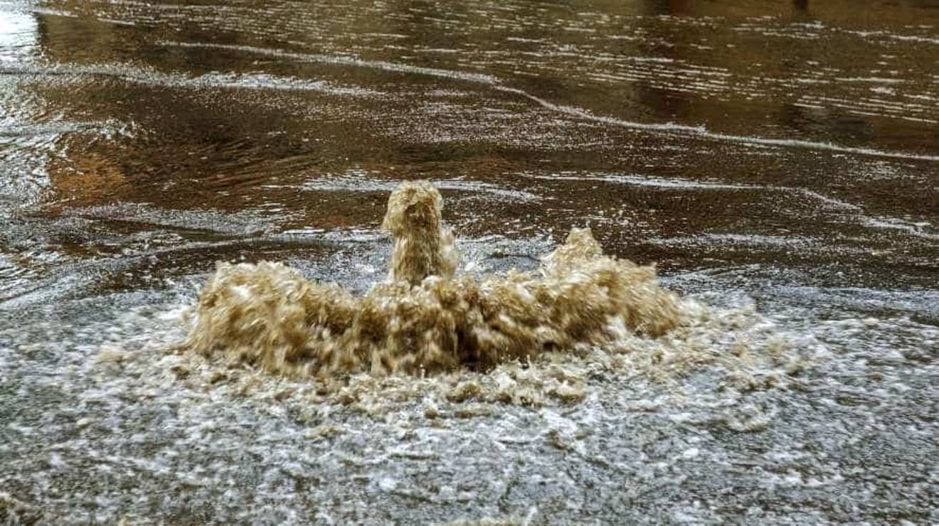 sewage flooding from manhole in the road