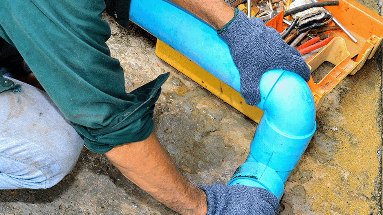 Man with a toolbox working on a water pipe 