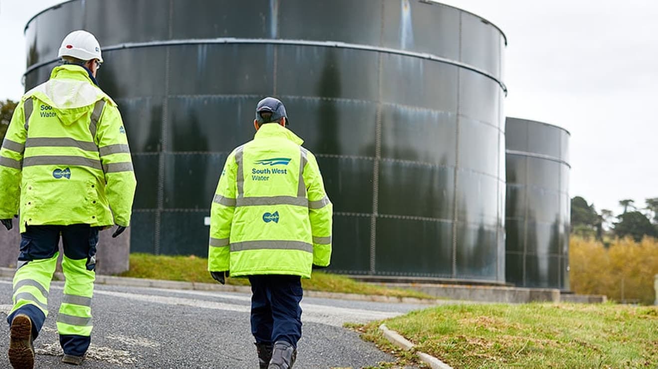 Two SWW employees walking towards water storage tanks