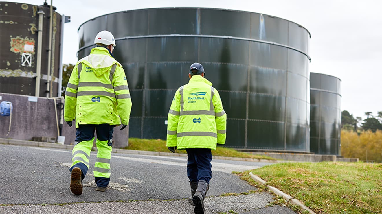 Two operatives walking towards storm overflows