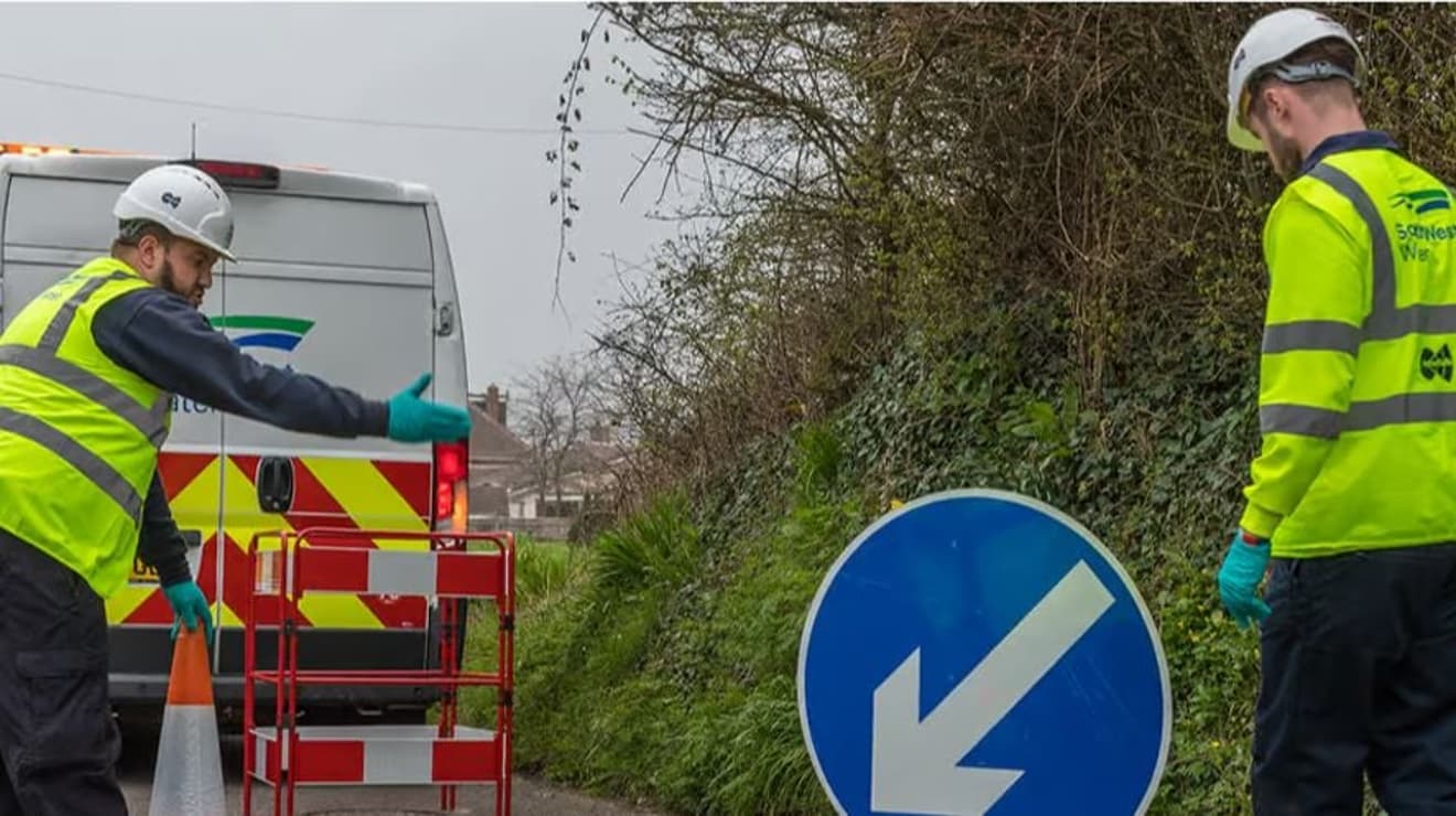 Two operatives working in the road behind a South West Water van