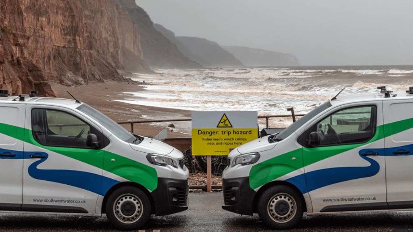 Two South West Water vans parked next to the red cliffs at Sidmouth