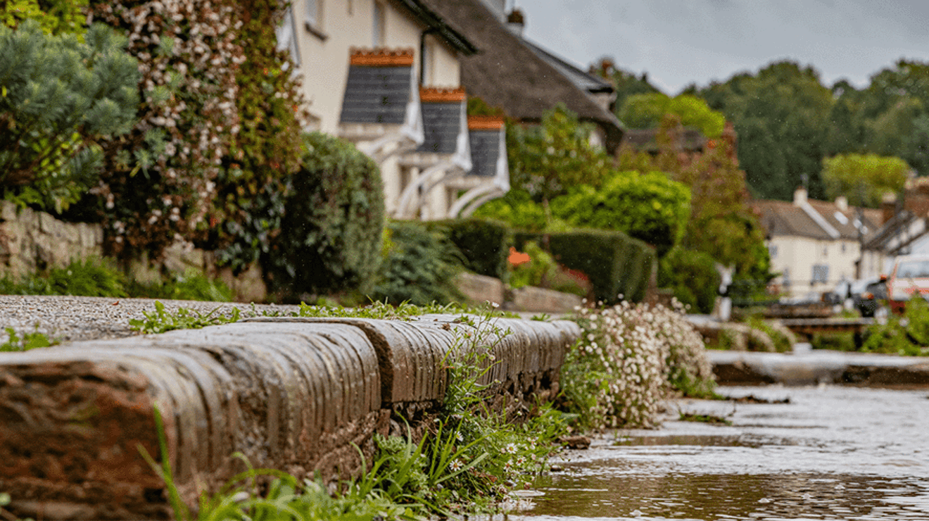 Worker flushing water in road