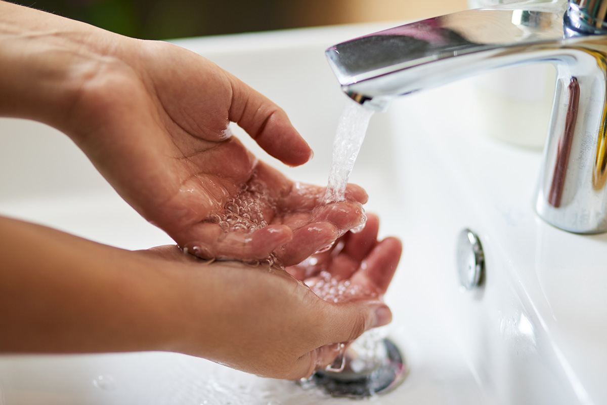 Image of person washing hands in a sink
