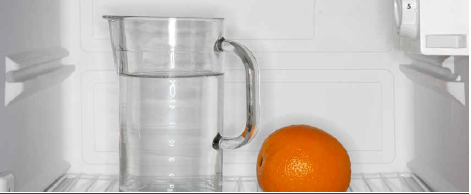 a jug of water next to an orange 