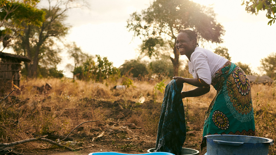 Image of woman in Malawi carrying a bucket of water