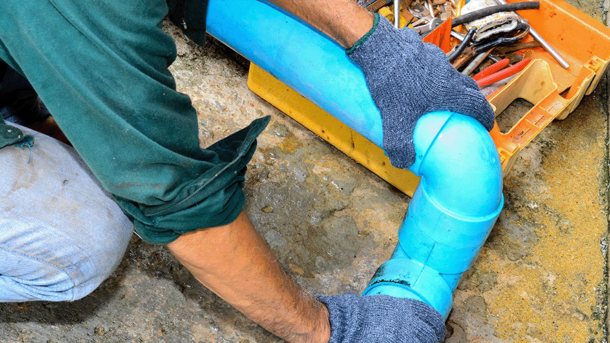 Man with a toolbox working on a water pipe 